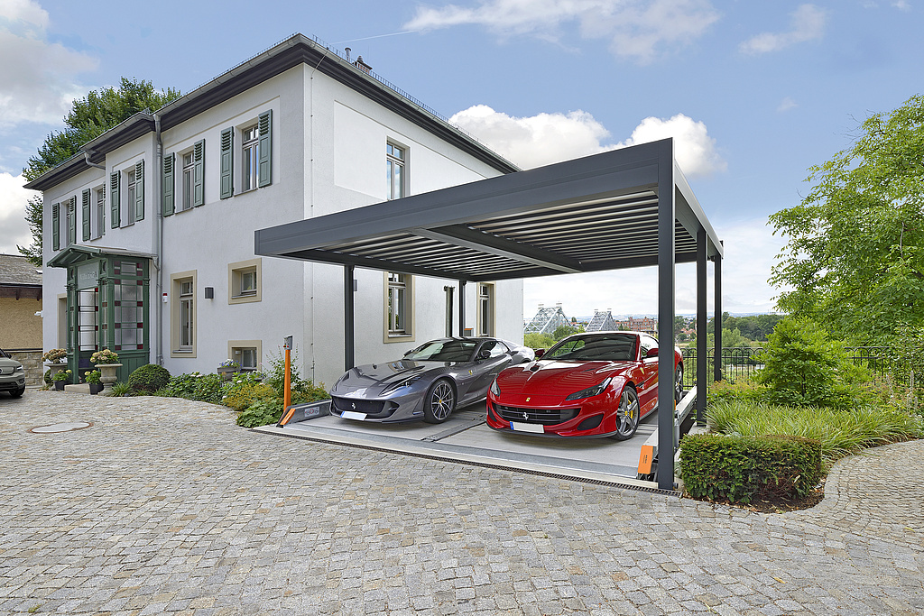 Property with carport and parking system on which 2 cars are parked