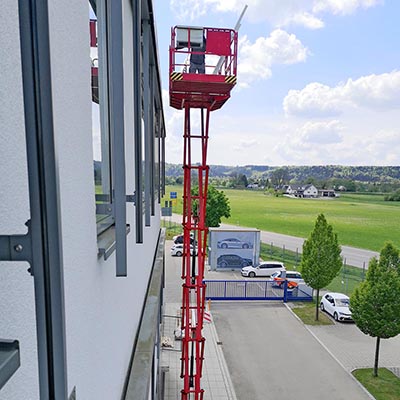 Firmenfassade mit Parkplatz und Hebebühne